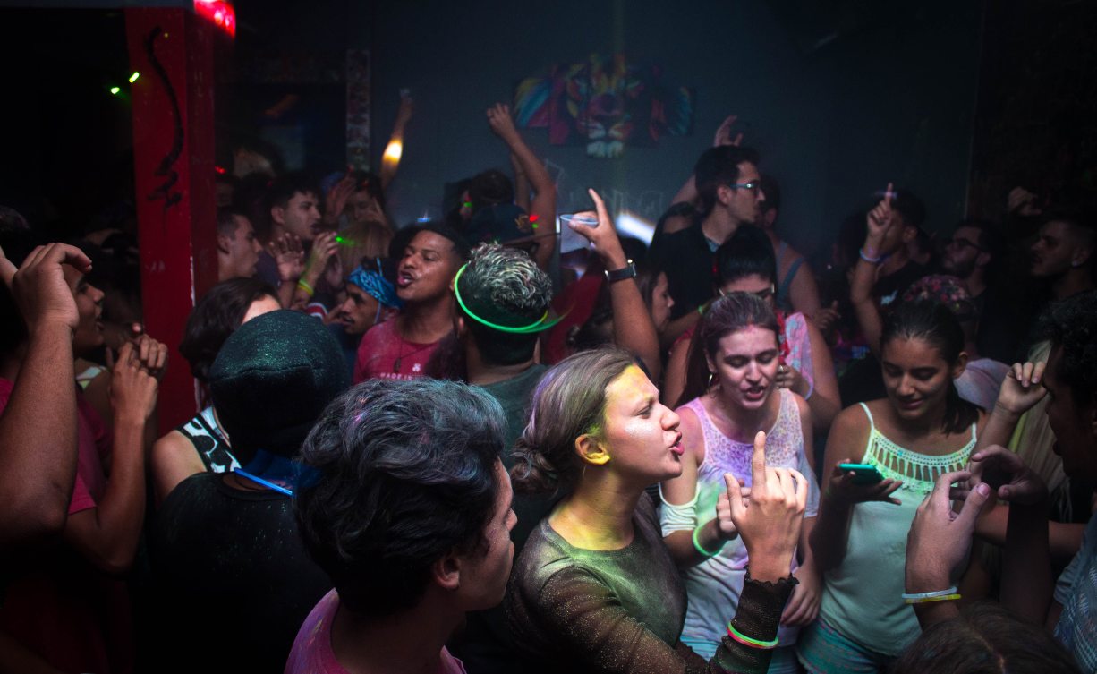 Basement party crowd enjoying portable speaker music